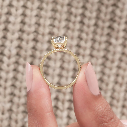 close view of oval-cut lab diamond curved bridal ring set with yellow gold band