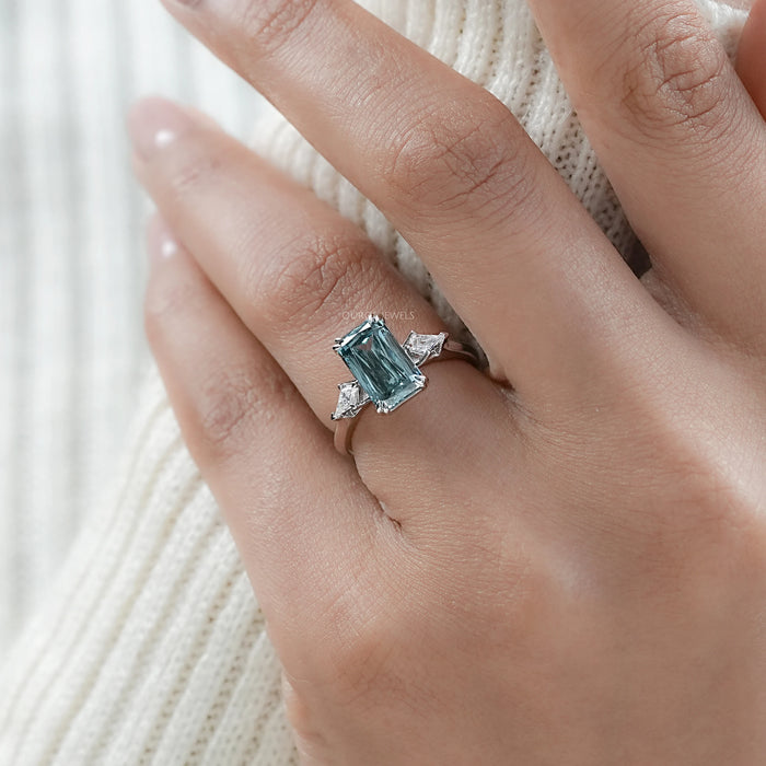 green scissors cut diamond double prong three stone engagement ring in model's finger