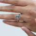 green scissors cut diamond double prong three stone engagement ring in finger