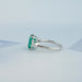 left view of emerald gemstone and bullet-cut diamond three-stone engagement ring