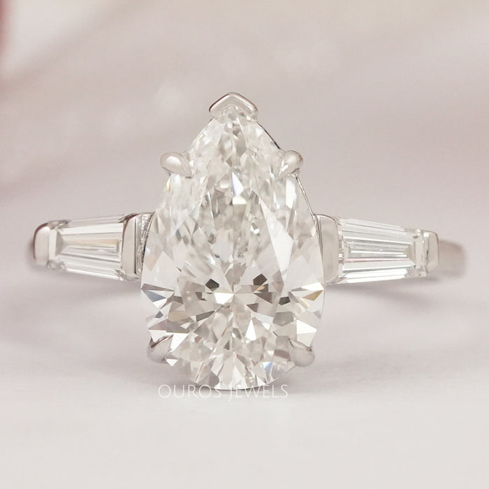 front view of pear cut with tapered baguettes diamond three stone wedding ring