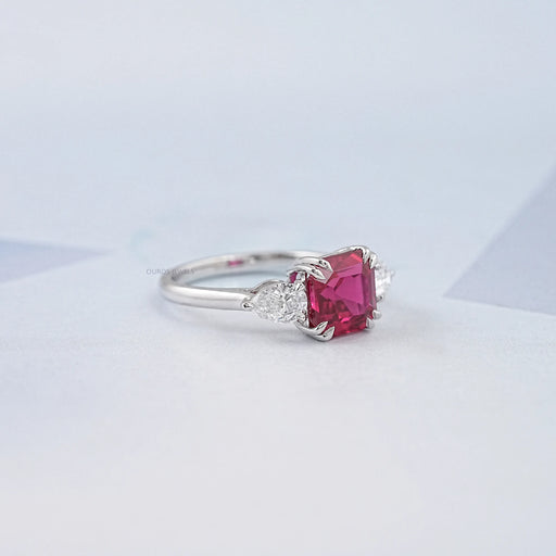 side view of asscher cut ruby and pear diamond double prong 3 stone engagement ring