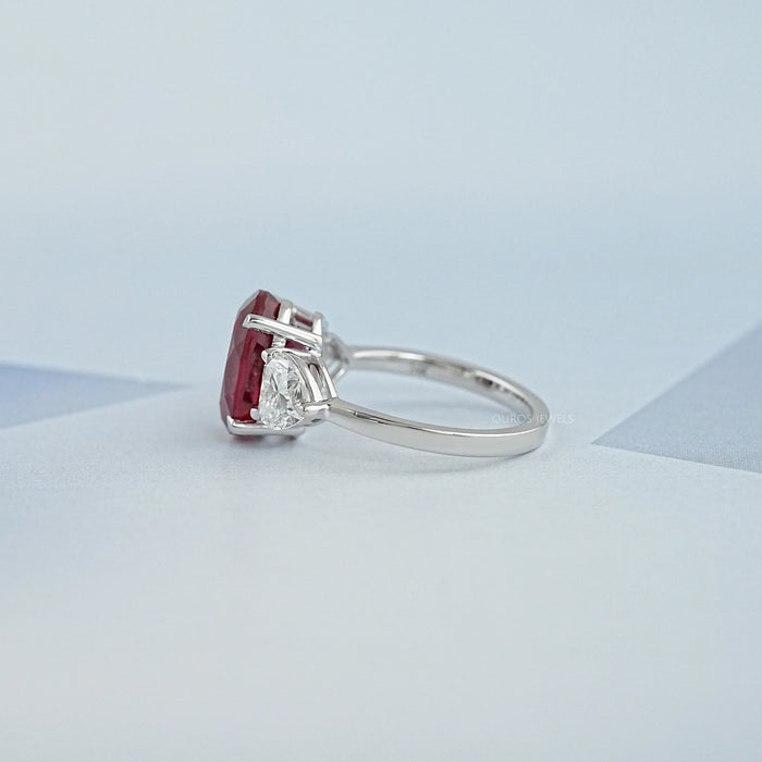side view of oval ruby gemstone with heart diamond 3 stone engagement ring