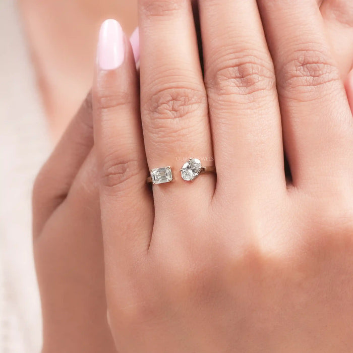 oval and emerald-cut lab diamond toi et moi engagement ring on model's finger