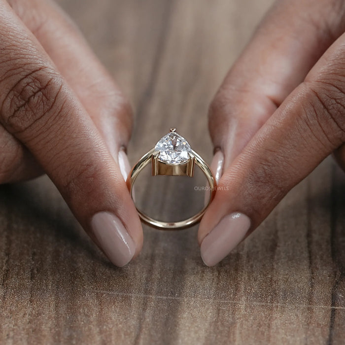 close up view of v shape pear cut lab diamond solitaire engagement ring