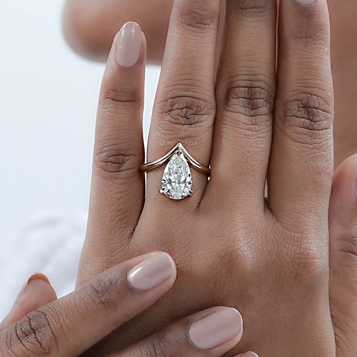 v shape pear cut lab diamond solitaire engagement ring on model's finger
