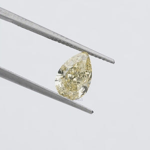 2.17 Carat Fancy Yellow Pear Cut Loose Diamond held by tweezers against a white background, showcasing its sparkling clarity and yellow color.