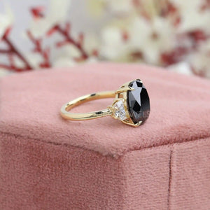 black oval cut diamond ring in yellow gold