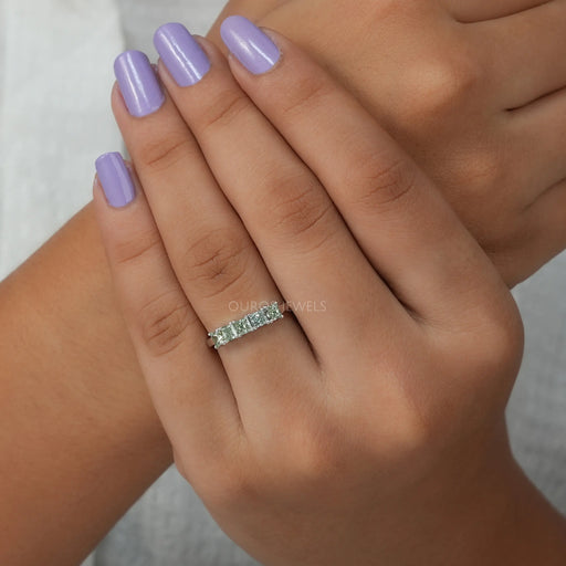 front view of pink and green princess cut diamond five stone wedding ring in finger