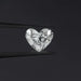 1 Carat IGI Certified Heart Cut Lab Grown Diamond hold by black tweezers against a dark background, highlighting its symmetrical cut and sparkling clarity.