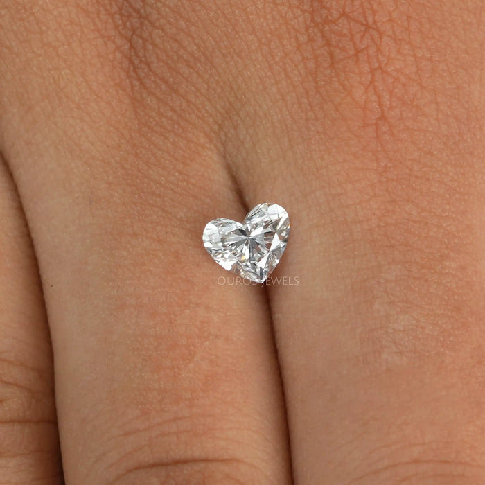 1 Carat IGI Certified Heart Cut Lab Grown Diamond placed on a finger, highlighting its brilliance and clarity against the skin.