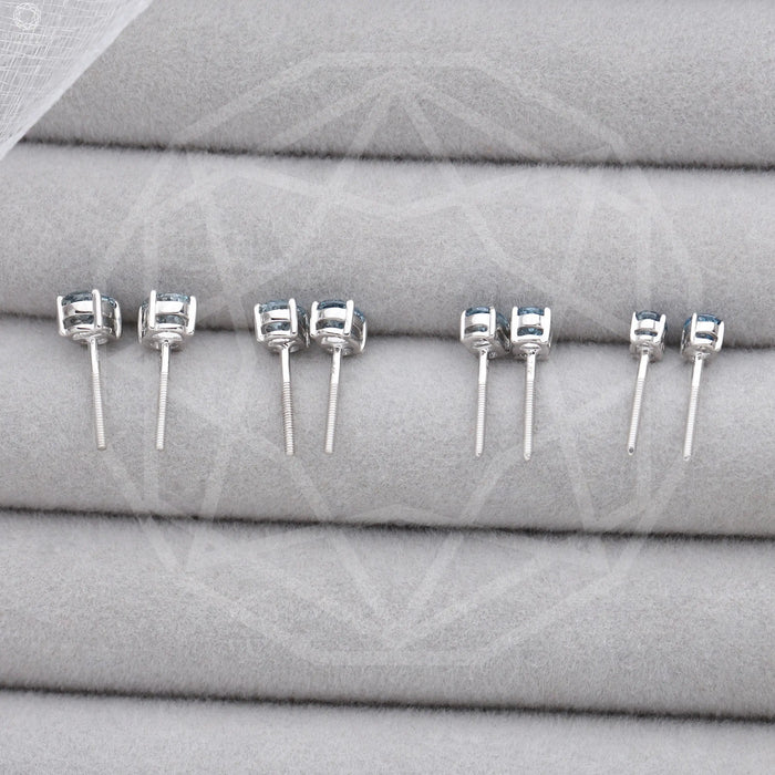 Blue Oval Cut Lab Diamond Stud Earrings shown from the back, highlighting the secure settings and posts, arranged on a gray fabric display.