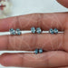 Blue Oval Cut Lab Diamond Stud Earrings displayed on a hand, featuring various sizes and showcasing their brilliance against a natural background.